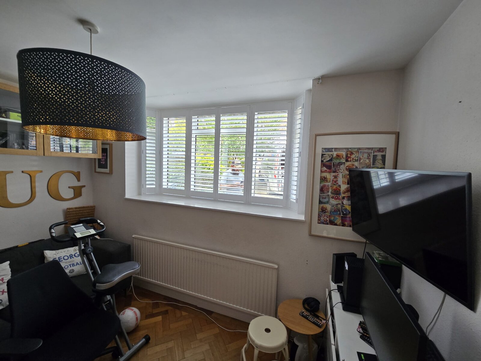 White hardwood shutters with hidden tilt and hidden split on a bay window in a High Wycombe snug