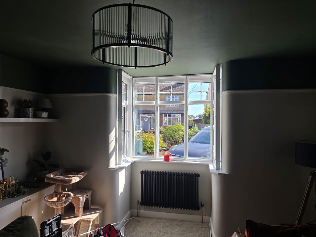 Snow White hardwood shutter panels folded open on a Northampton bay window