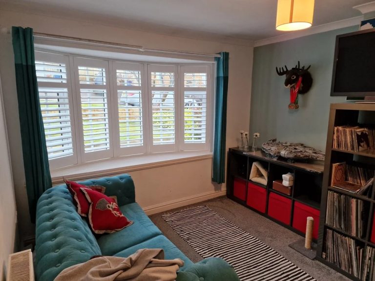 Full height shutters fitted in a bay window of a UK home