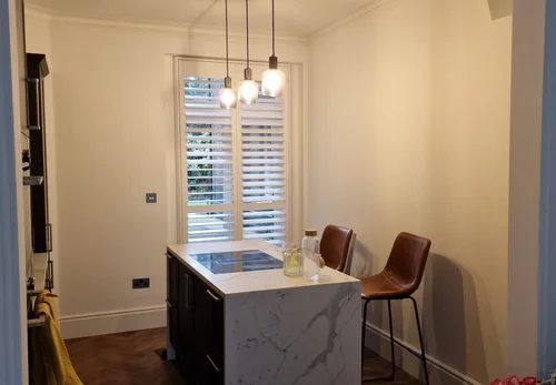 Full height white shutters fitted on a tall window